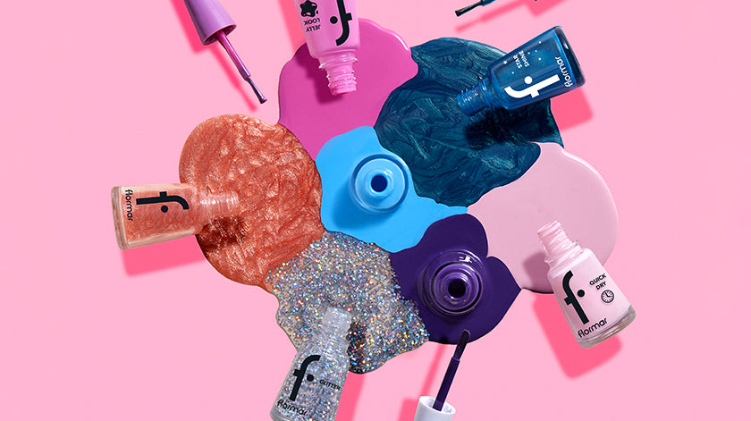 Flormar nail polish collection in glittery, metallic, and vibrant shades, displayed with colorful paint splashes on a pink background.
